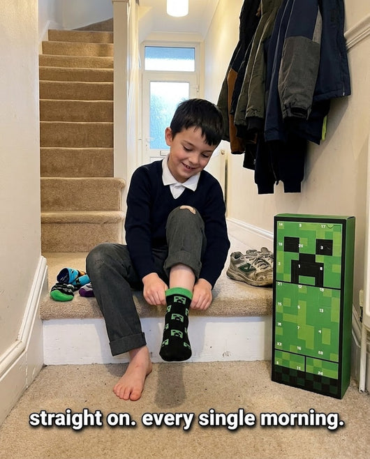 Boy putting on Minecraft socks from the advent calendar before school
