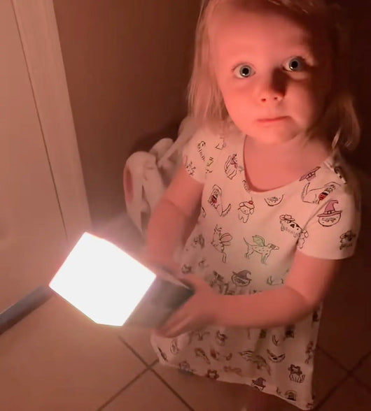 Little girl holding the glowing Pixel Torch at night
