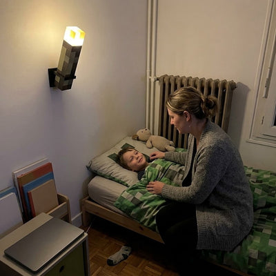 Pixel Torch on the bedroom wall as a soft night light while mom tucks her son in