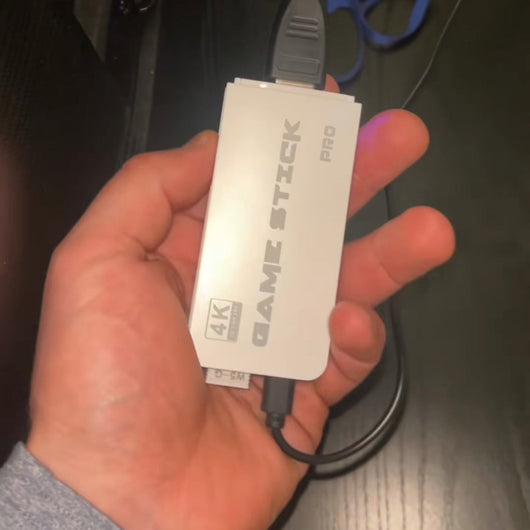 RetroStick Pro in the hand, ready to plug into the TV